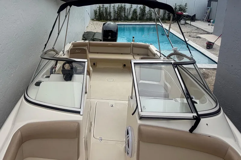 Slide: The Image of 2023 Scout 210 Dorado boat with open cockpit, near a swimming pool. - 7