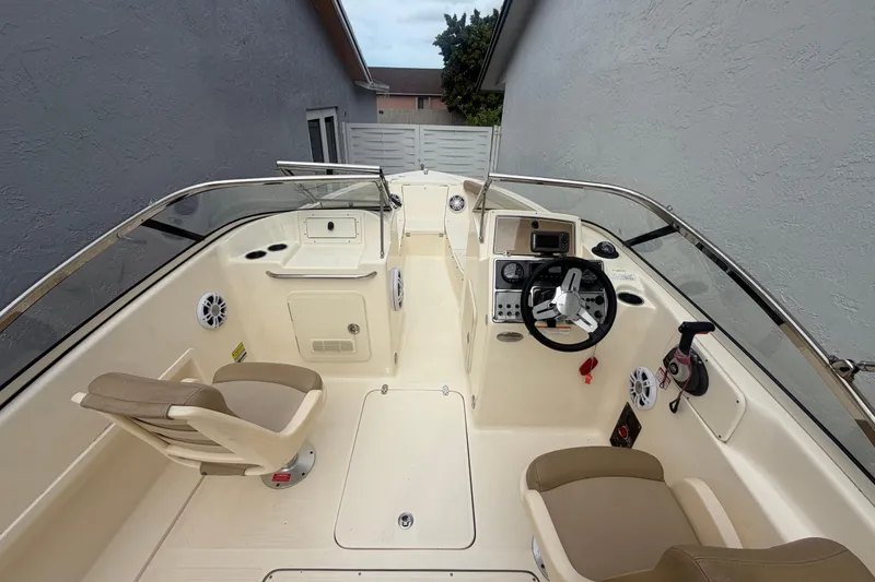 Slide: The Image of 2023 Scout 210 Dorado boat interior with steering wheel and seating. - 8