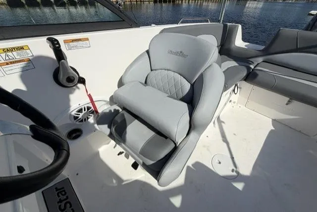 Slide: The Image of 2023 NauticStar 223 DC boat interior with gray seating and steering wheel. - 15