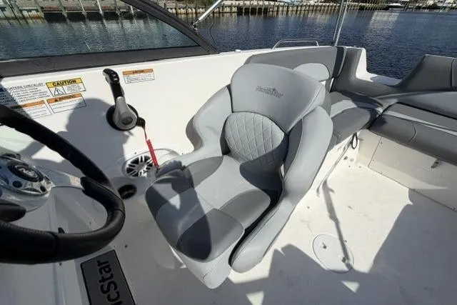 Slide: The Image of 2023 NauticStar 223 DC boat interior with gray seating and steering wheel. - 16