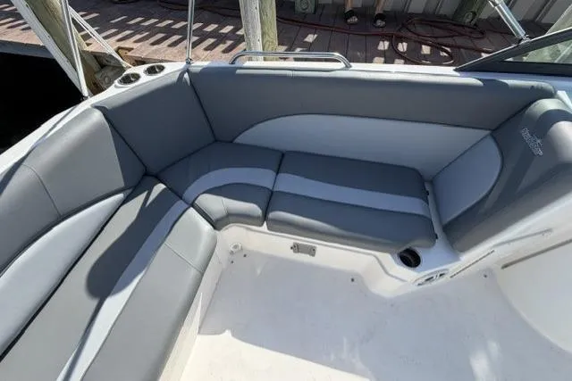 Slide: The Image of 2023 NauticStar 223 DC boat interior with gray seating and cup holders. - 23