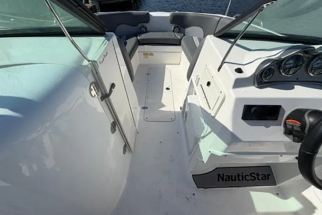Slide: The Image of 2023 NauticStar 223 DC boat interior with seating and dashboard view. - 24
