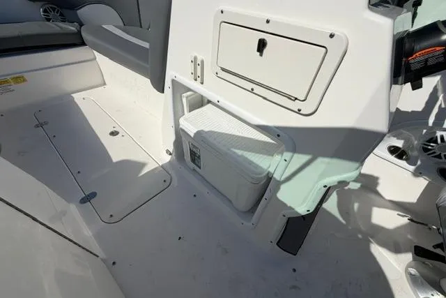Slide: The Image of 2023 NauticStar 223 DC boat interior with storage compartment and cooler. - 27