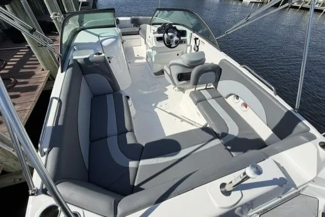 Slide: The Image of 2023 NauticStar 223 DC boat interior with gray seating, steering wheel, and water view. - 28