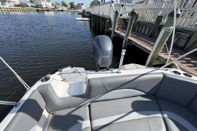 Slide: The Image of 2023 NauticStar 223 DC boat docked, featuring a 150 HP outboard motor. - 29