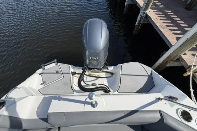 Slide: The Image of 2023 NauticStar 223 DC boat with outboard motor, docked by wooden pier. - 30