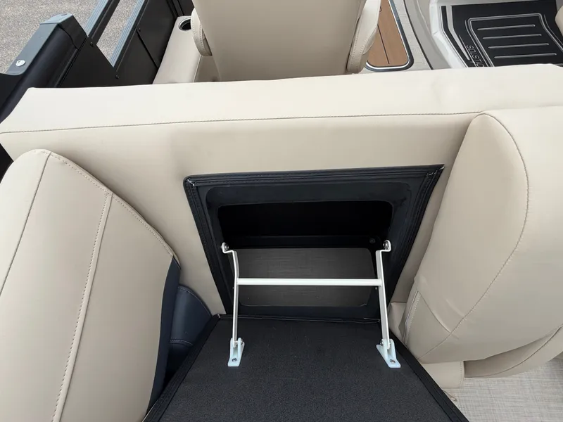 Slide: The Image of Rear view of a beige boat seat with an open storage compartment and metal support. - 24