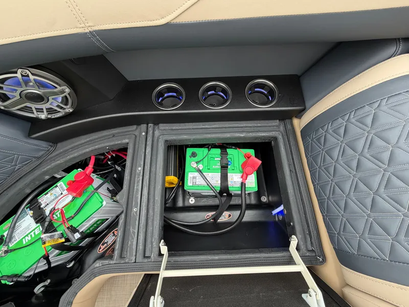 Slide: The Image of An open battery compartment in a boat with two green batteries and speakers. - 21