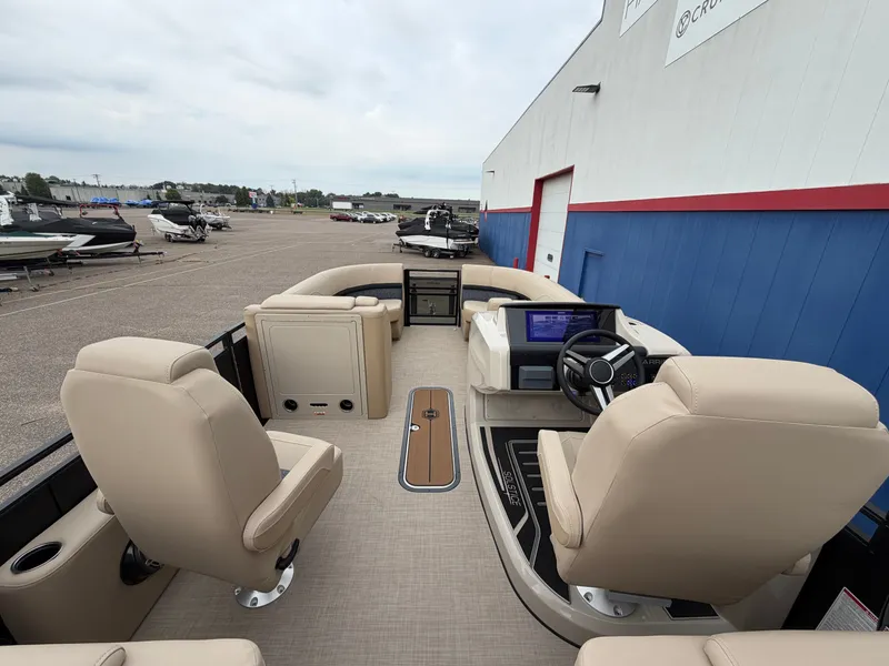 Slide: The Image of The image shows the interior of a 2027 Harris 230SOL pontoon boat with beige seating and a modern helm. - 26
