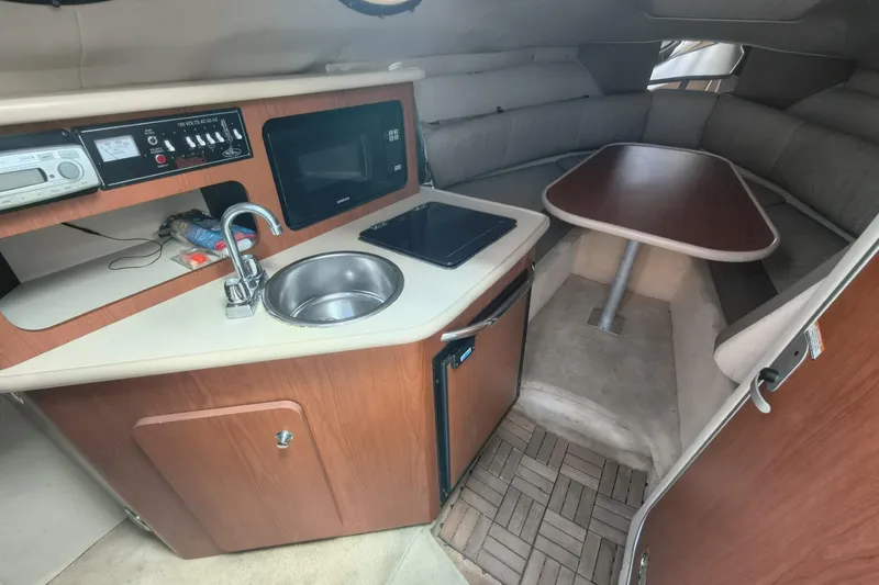Slide: The Image of 2004 Chaparral Signature 240 cabin interior with kitchenette, sink, and dining area. - 10