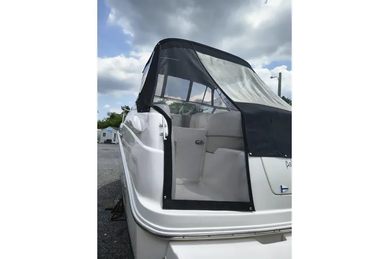 Slide: The Image of 2004 Chaparral Signature 240 boat with black canopy, parked outdoors under cloudy sky. - 3