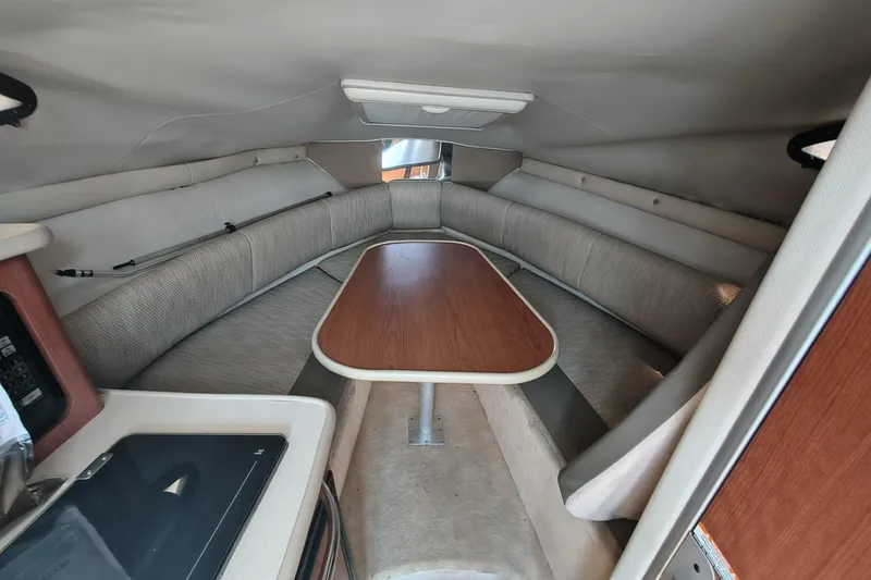 Slide: The Image of 2004 Chaparral Signature 240 cabin interior with seating and wooden table. - 9