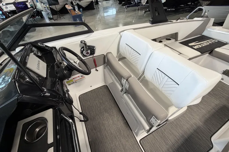 Slide: The Image of 2024 Glastron GTD 240 boat interior with steering wheel, Garmin display, and white seating. - 20