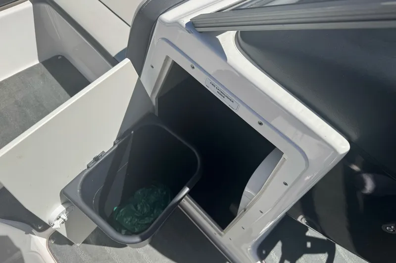 Slide: The Image of Storage compartment with trash bin on a 2022 Yamaha Boats AR190. - 19