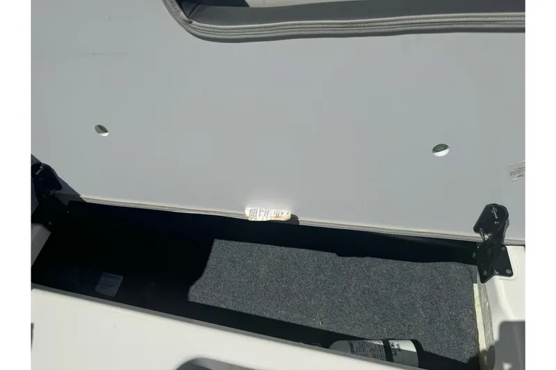 Slide: The Image of Storage compartment of 2022 Yamaha Boats AR190, featuring carpeted interior and safety equipment. - 29