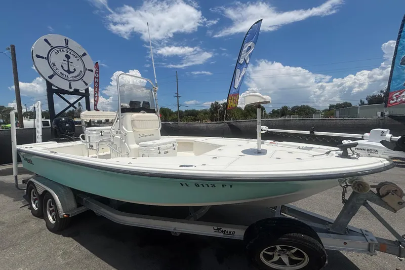 The Image of 2014 Mako 21 LTS boat on trailer, displayed outdoors under a clear sky. - 0