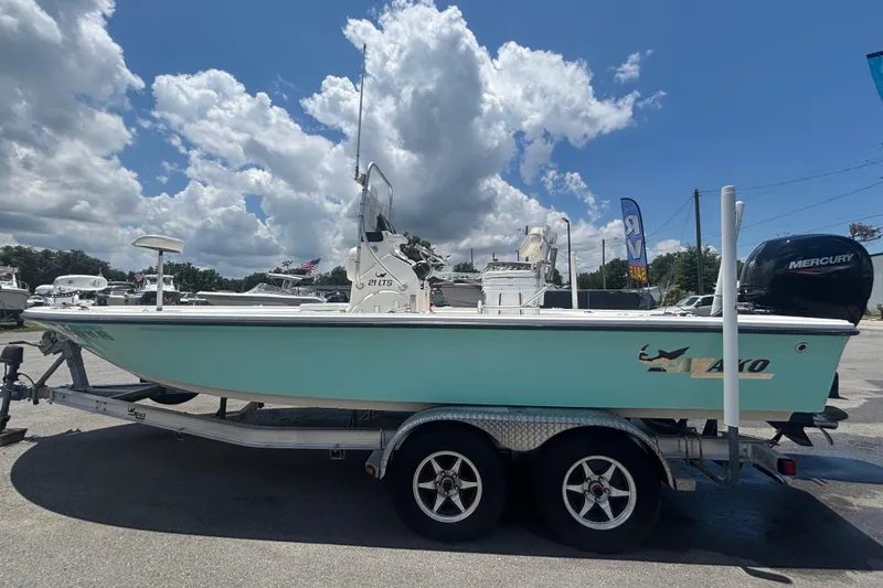 Slide: The Image of 2014 Mako 21 LTS boat on trailer under a cloudy sky. - 10
