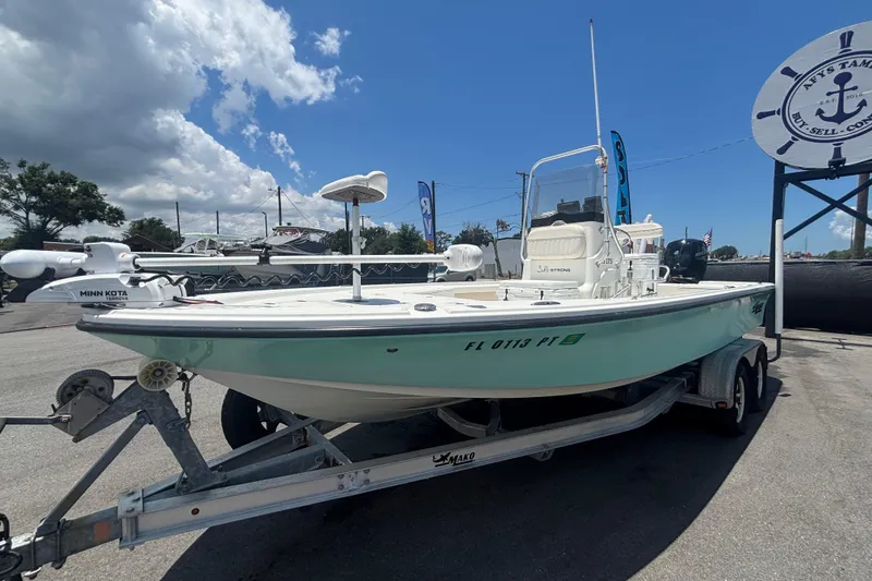 Slide: The Image of 2014 Mako 21 LTS boat on trailer under clear blue sky. - 11
