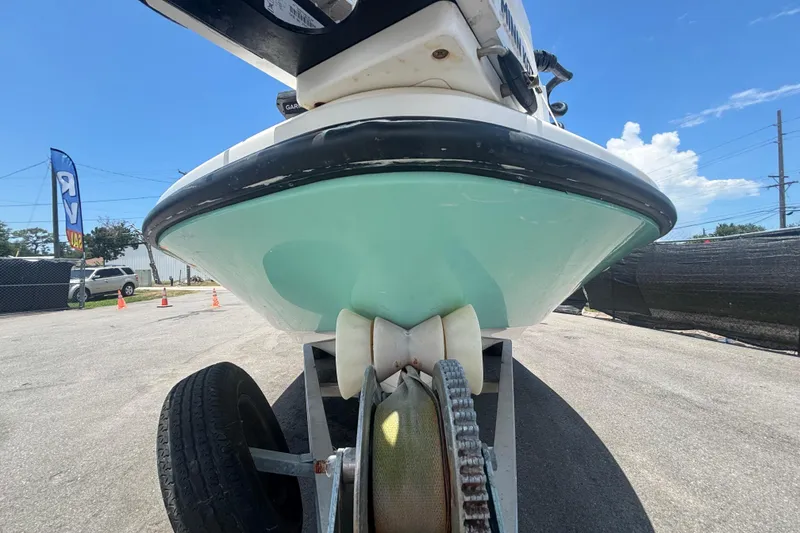 Slide: The Image of 2014 Mako 21 LTS boat on trailer, viewed from below, in sunny outdoor setting. - 12
