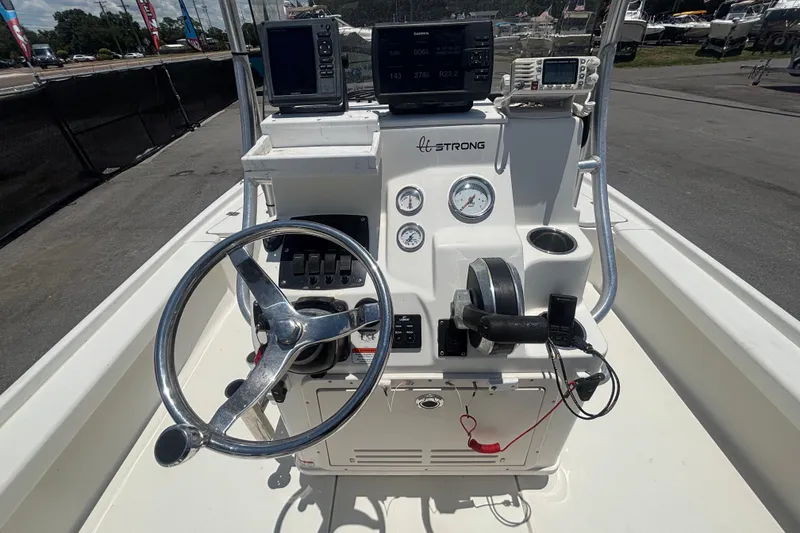 Slide: The Image of 2014 Mako 21 LTS boat console with steering wheel and navigation equipment. - 18