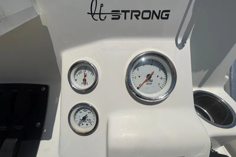 Slide: The Image of Dashboard of a 2014 Mako 21 LTS boat with fuel and RPM gauges. - 22