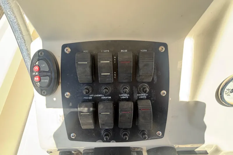 Slide: The Image of Control panel of a 2014 Mako 21 LTS boat with various switches and buttons. - 23