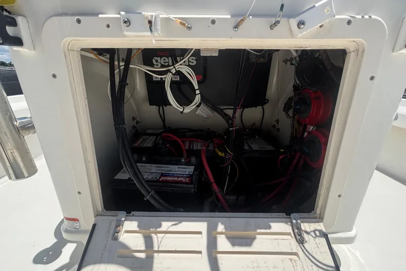 Slide: The Image of 2014 Mako 21 LTS boat battery compartment with wiring and components. - 25