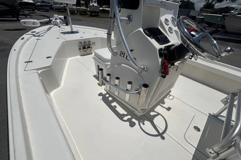 Slide: The Image of 2014 Mako 21 LTS boat interior with steering console and rod holders. - 26