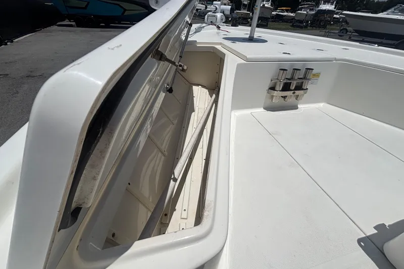 Slide: The Image of 2014 Mako 21 LTS boat deck with open storage compartment and rod holders. - 28