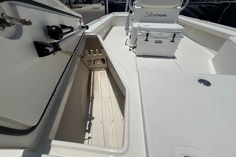 Slide: The Image of 2014 Mako 21 LTS boat interior with storage compartment and Yeti cooler. - 35