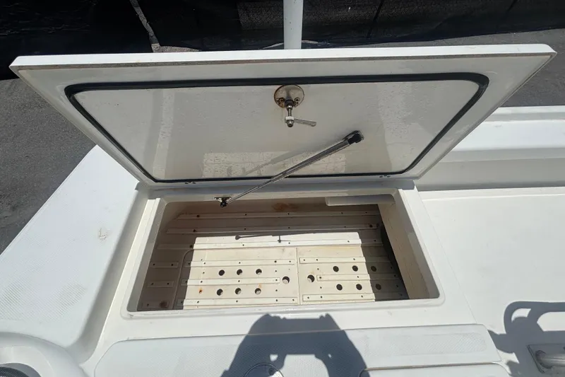 Slide: The Image of Open storage compartment on a 2014 Mako 21 LTS boat, showing interior details. - 44