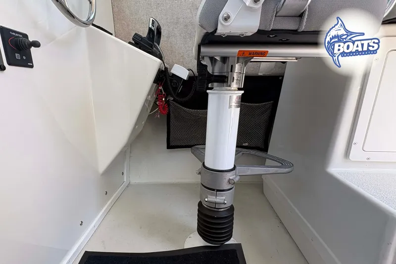 Slide: The Image of Interior of 2021 Parker 2520 XLD Sport Cabin boat, featuring steering and seating area. - 13