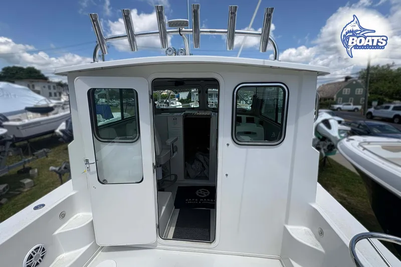 Slide: The Image of 2021 Parker 2520 XLD Sport Cabin boat with open cabin door, docked outdoors. - 6