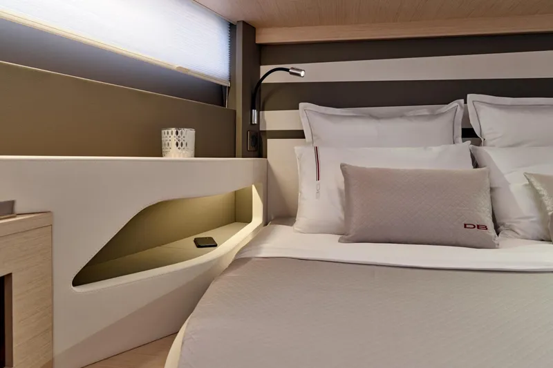 Slide: The Image of Luxurious cabin interior of 2027 Jeanneau DB/43 OB yacht with modern bedding and ambient lighting. - 13