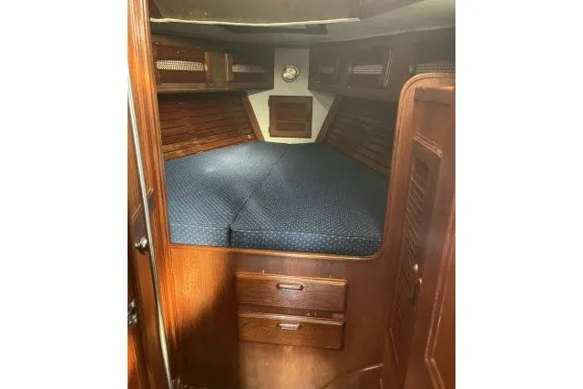 Slide: The Image of Cozy cabin interior of 1985 Islander Peterson 40 sailboat with wooden finish and blue bedding. - 14