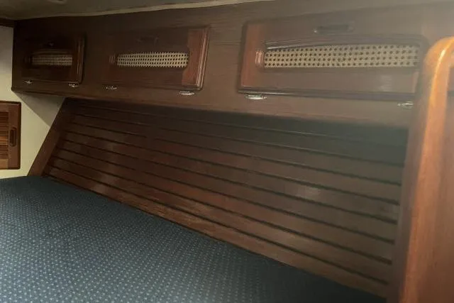 Slide: The Image of Interior of 1985 Islander Peterson 40 sailboat with wooden cabinetry and blue upholstery. - 17