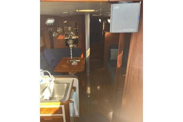 Slide: The Image of Interior of 1985 Islander Peterson 40 yacht, featuring a cozy dining area and wooden finishes. - 2