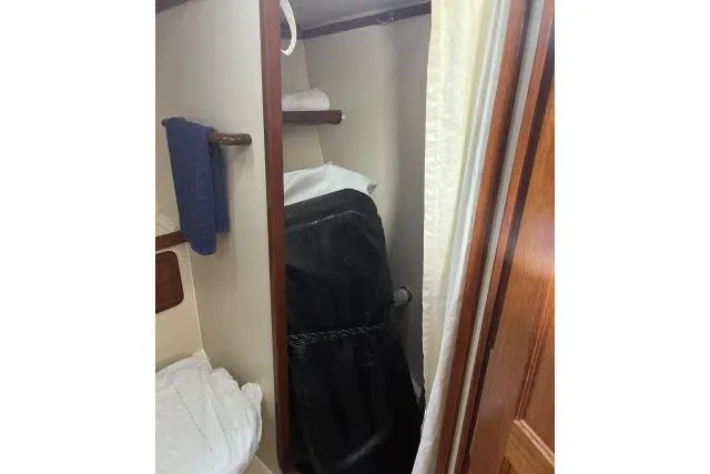 Slide: The Image of Interior of 1985 Islander Peterson 40 sailboat with compact storage area and hanging clothes. - 20