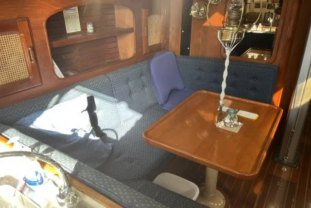 Slide: The Image of Interior of 1985 Islander Peterson 40 sailboat with cozy seating and wooden table. - 3