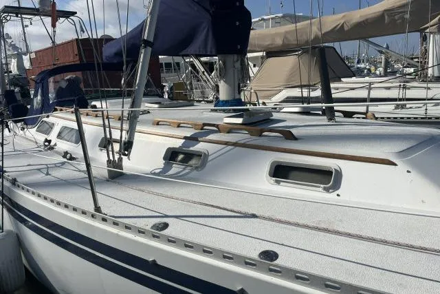 Slide: The Image of 1985 Islander Peterson 40 sailboat docked at marina, showcasing sleek design and rigging. - 30