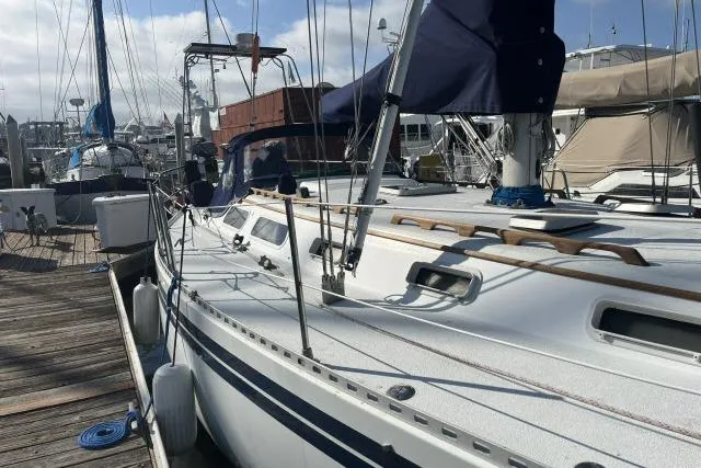 Slide: The Image of 1985 Islander Peterson 40 sailboat docked at marina, showcasing sleek design and rigging. - 31
