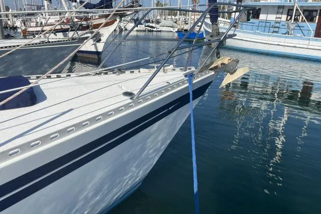 Slide: The Image of 1985 Islander Peterson 40 sailboat docked in a marina, featuring sleek design and blue accents. - 33