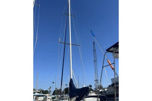 Slide: The Image of 1985 Islander Peterson 40 sailboat mast against clear blue sky in marina. - 37