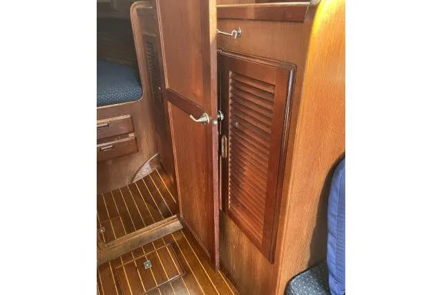 Slide: The Image of Wooden interior of 1985 Islander Peterson 40 sailboat, featuring a cabin door and louvered panel. - 5