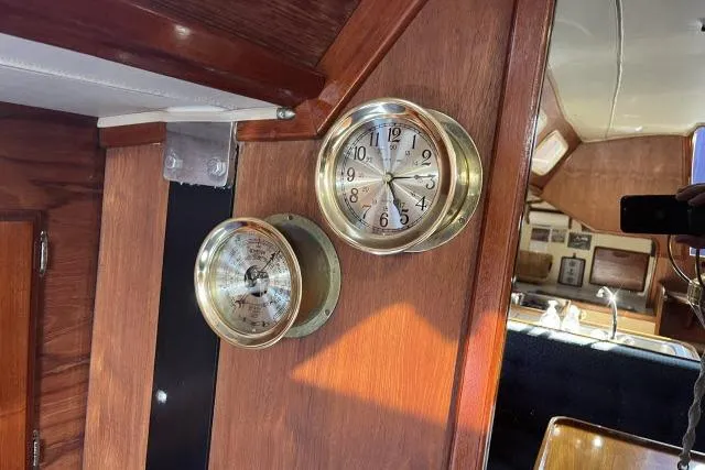 Slide: The Image of Interior of 1985 Islander Peterson 40 yacht with brass clock and barometer on wooden panel. - 6