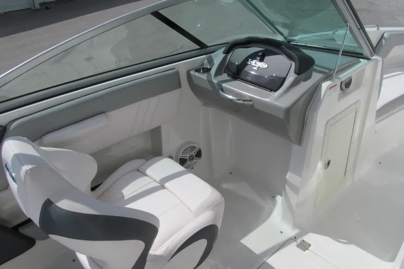Slide: The Image of 2019 Chaparral 21 H2O Sport boat interior with white seating and sleek dashboard design. - 7