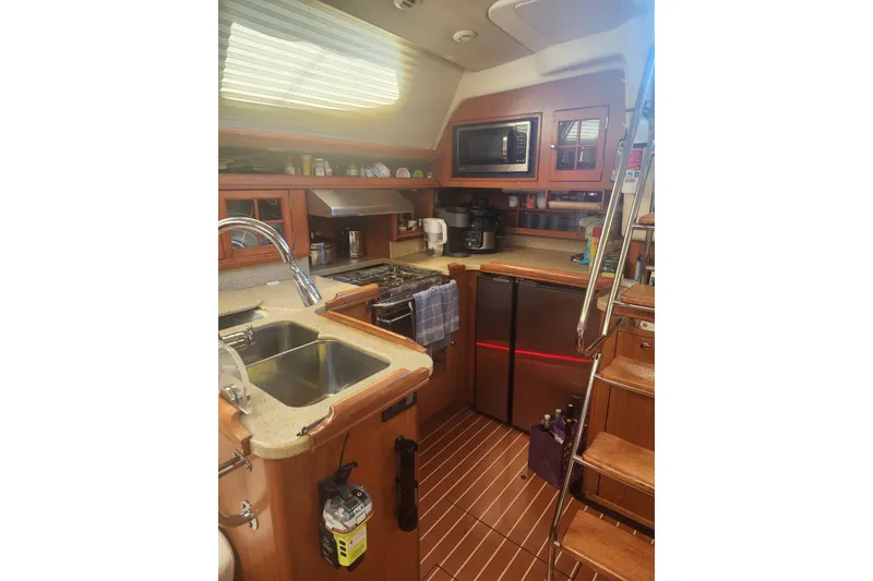 Slide: The Image of 2008 Hunter 450 yacht kitchen with modern appliances and wooden cabinetry. - 12
