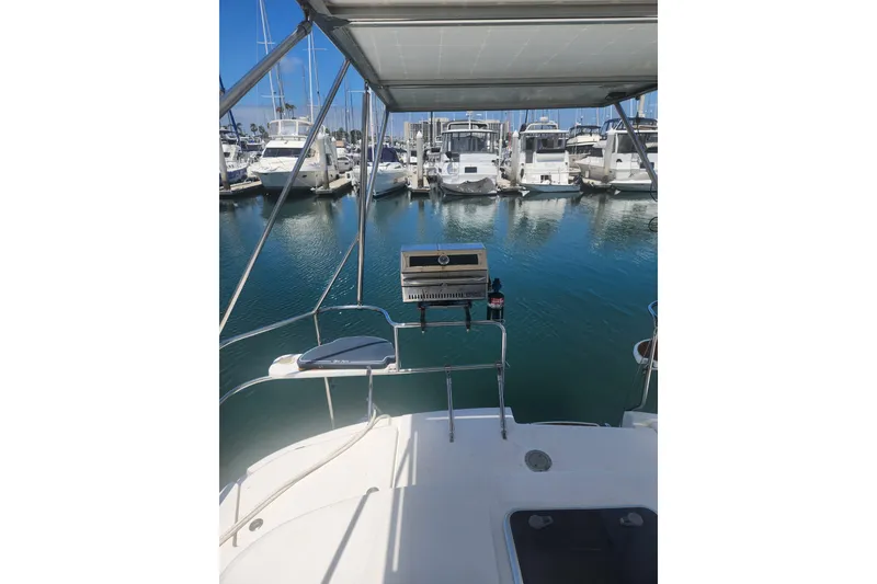Slide: The Image of 2008 Hunter 450 yacht docked in marina, featuring outdoor grill and seating area. - 4