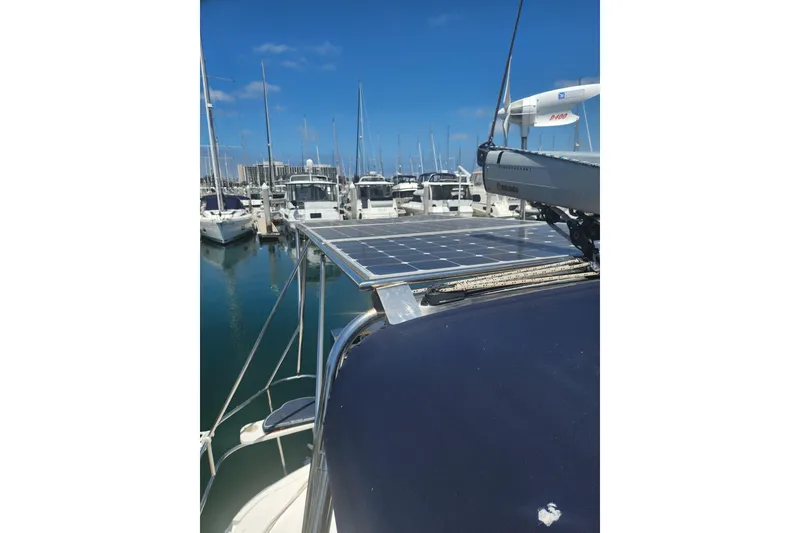 Slide: The Image of Hunter 450 sailboat with solar panels docked at marina, clear blue sky. - 5