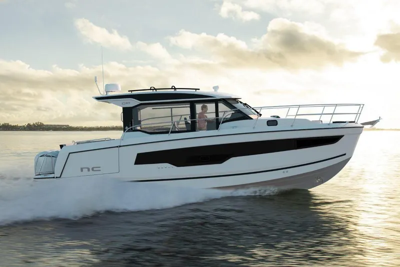 Slide: The Image of Manufacturer Provided Image: 2026 Jeanneau NC 1095 Coupe Series 2 cruising on calm waters at sunset. - 1